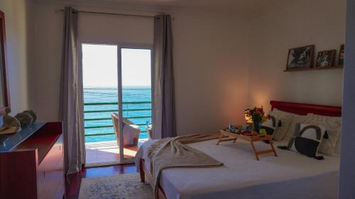 a bedroom with a bed and a view of the ocean at Villa Frente Mar by ESCAPE to Madeira in Funchal