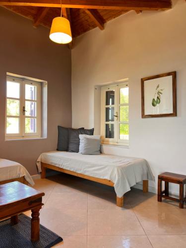 a bedroom with a bed and two windows at Garys Old Farmhouse in Kamária