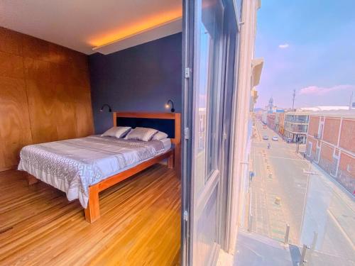 a bedroom with a bed and a large window at Spacious modern and centrally located in Puebla