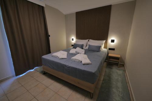 a bedroom with a large bed with towels on it at Aithra Suite - Europa Hotel in Korinos