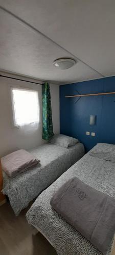 a bedroom with two beds and a window at Location mobil-home camping Pedro Confort & détente in Le Grau-dʼAgde