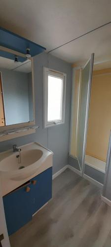 a bathroom with a sink and a window at Location mobil-home camping Pedro Confort & détente in Le Grau-dʼAgde
