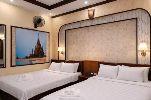 a hotel room with two beds with white sheets at Đức Anh Hotel Ninh Binh in Ða Gia