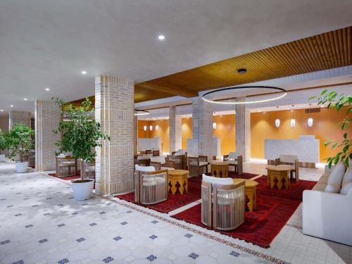 a lobby of a hotel with tables and chairs at Mercure Bukhara Old Town in Bukhara
