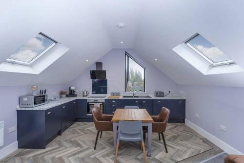 a kitchen with blue cabinets and a table with chairs at Luxury modern Loft apartment by Bootique in Wakefield