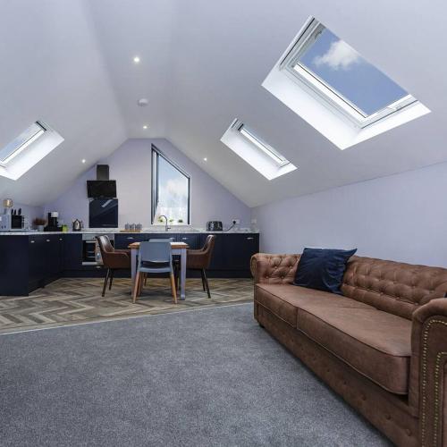 a living room with a couch and a table with chairs at Luxury modern Loft apartment by Bootique in Wakefield