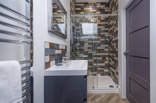 a bathroom with a sink and a shower at Luxury modern Loft apartment by Bootique in Wakefield