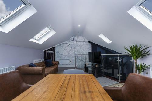 a living room with a wooden table and a couch at Luxury modern Loft apartment by Bootique in Wakefield