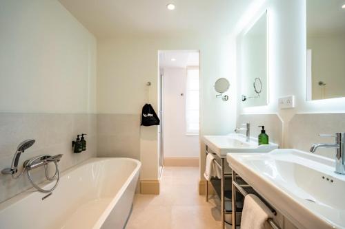 a white bathroom with two sinks and a tub at Hôtel Villa Maïtia in Ustaritz