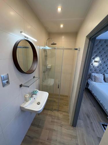 a bathroom with a shower and a sink and a mirror at VILLA SOLARIS Ustka - PENSJONAT Z 2026R,ROWERY GRATIS, WYPOCZYNEK tylko DLA DOROSŁYCH ! in Ustka