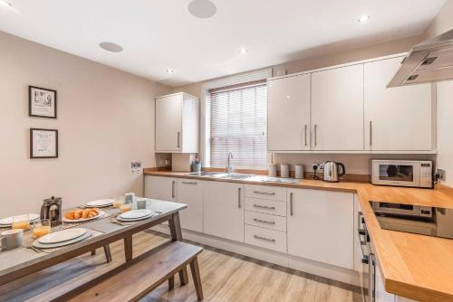 a kitchen with white cabinets and a table with food on it at Great Gate House View - within York Walls in York
