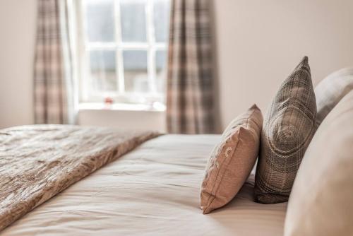 a bed with two pillows on it with a window at Great Gate House View - within York Walls in York