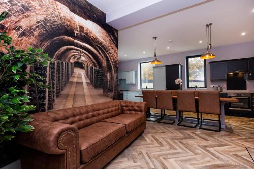 a living room with a couch and a brick wall at BOOTique House - Luxury Group Accommodation for 12 in Wakefield