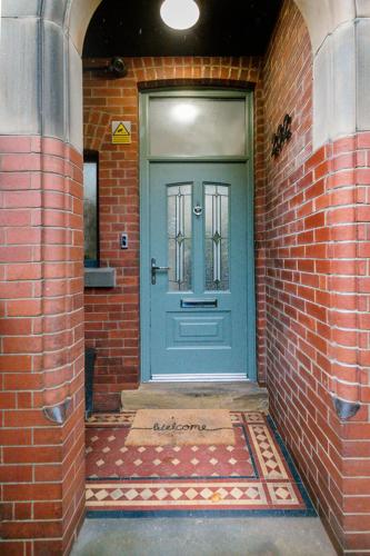 a blue door on a brick building with a brick wall at BOOTique House - Luxury Group Accommodation for 12 in Wakefield
