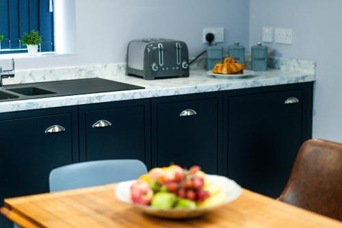 a bowl of fruit on a table in a kitchen at BOOTique House - Luxury Group Accommodation for 12 in Wakefield