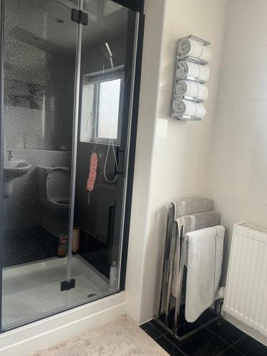 a shower with a glass door in a bathroom at Cozy Room at Willow House in Leyland