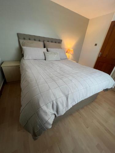 a bedroom with a large bed with a gray comforter at Cozy Room at Willow House in Leyland