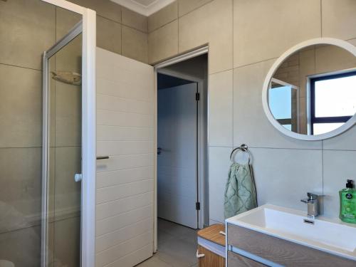 a bathroom with a sink and a mirror at Beach Haus Unit 1 in Cape Town