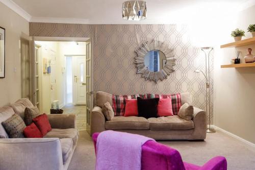 a living room with a couch and a mirror at Stylish family home in desirable Penylan + Parking in Cardiff