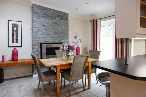 a dining room with a table and chairs and a fireplace at Stylish family home in desirable Penylan + Parking in Cardiff