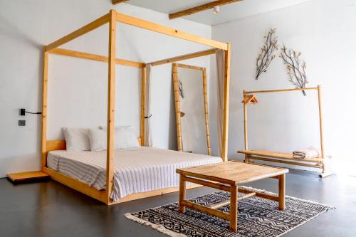 a bedroom with a canopy bed and a table at Lilium Rooms in Çeşme