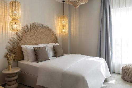 a white bedroom with a large white bed with pillows at Cavo Dio 8 - Beachfront bliss - Cozy Apt Pool Sunset in Káto Dhiminión