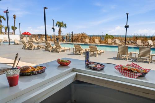 a table with bowls of food on it next to a pool at Grande Beach Resort in Myrtle Beach