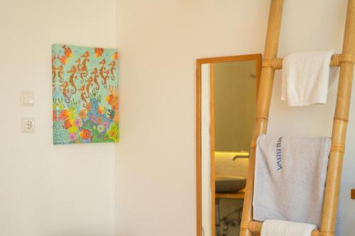 a bathroom with a towel rack and a mirror at Lilium Rooms in Çeşme