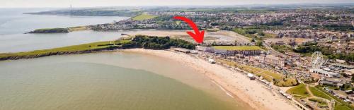 an aerial view of a beach with a red arrow at Barry Island Beachfront Apartment - Stunning Bay Views and Private Parking in Barry