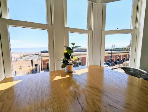 a table with a potted plant sitting on top of it at Barry Island Beachfront Apartment - Stunning Bay Views and Private Parking in Barry