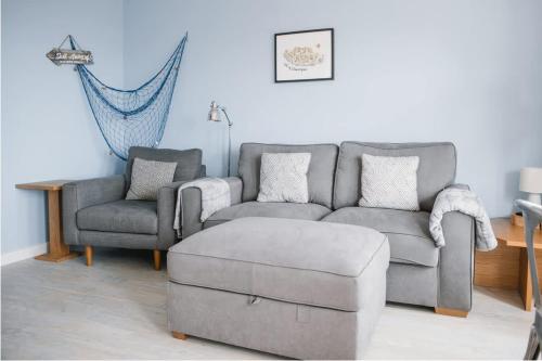 a living room with a couch and two chairs at Barry Island Beachfront Apartment - Stunning Bay Views and Private Parking in Barry