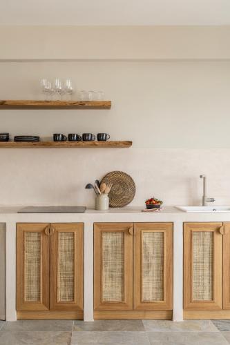 a kitchen with wooden cabinets and a sink at Cavo Dio 8 - Beachfront bliss - Cozy Apt Pool Sunset in Káto Dhiminión