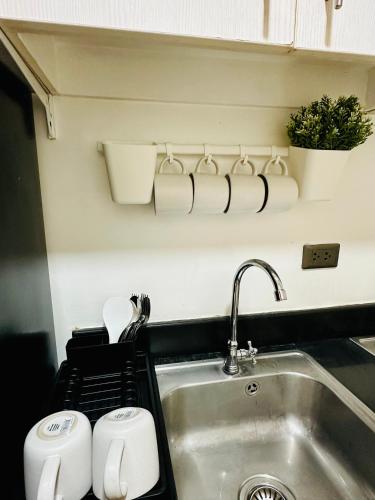 a kitchen counter with a sink and a sink at Aeva's Cozy Stays in Manila