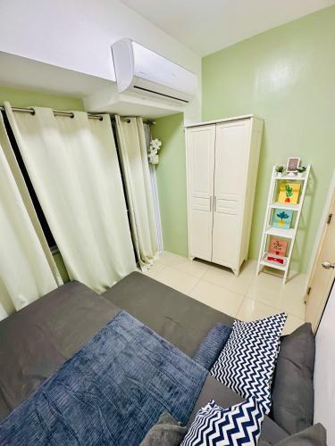 a small bedroom with a bed and a closet at Aeva's Cozy Stays in Manila