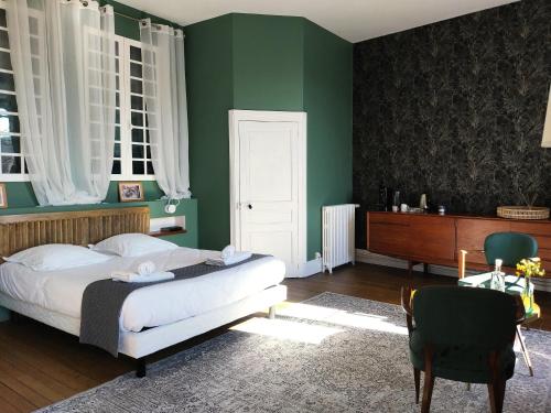 a bedroom with a bed and a green wall at Maison Tyto Alba in Saint-Victurnien