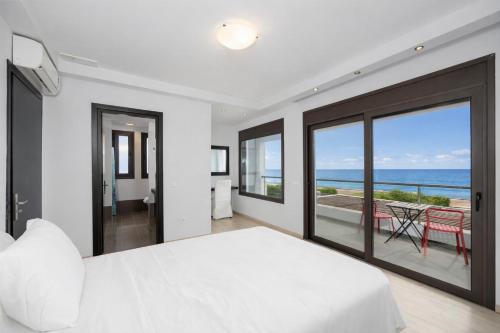 a bedroom with a bed and a view of the ocean at Villa Metis in Lachania