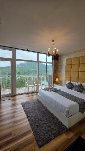a bedroom with a large bed and a large window at Hotel Bonavista in Nuwara Eliya
