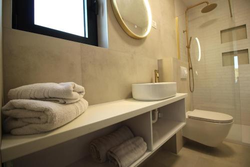 a bathroom with a sink and a toilet and a mirror at Villa Solis in Novalja