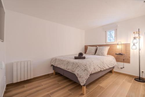a bedroom with a large bed in a white room at Studio élégant en RDC, confort et simplicité in Vaires-sur-Marne