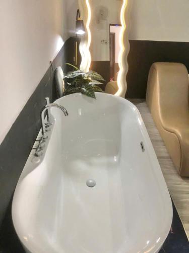 a white sink in a room with a couch at Hotel Đông Ngô Biên Hòa in Ấp Thành