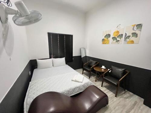 a bedroom with a bed and a leather chair at Hotel Đông Ngô Biên Hòa in Ấp Thành