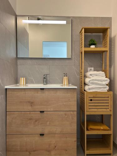 a bathroom with a sink and a mirror and towels at Ô Ptit Verger in Coulon