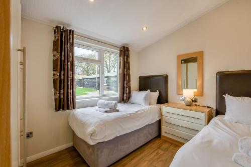 a bedroom with two beds and a window at Field View 2 bed 'S'- Spruce in Eye