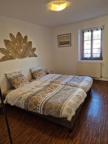 a bedroom with a bed and a window at Le repaire des Manalas in Ingersheim