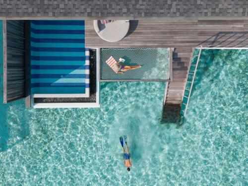 an overhead view of a person in a swimming pool at SO/ Maldives in South Male Atoll
