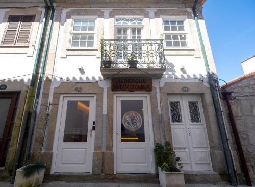 a white building with a balcony above the door at Albergue Santiago de Caminha in Caminha