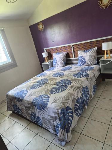 a bedroom with a bed with a blue and white comforter at gîte La Cannaie in Port-Louis