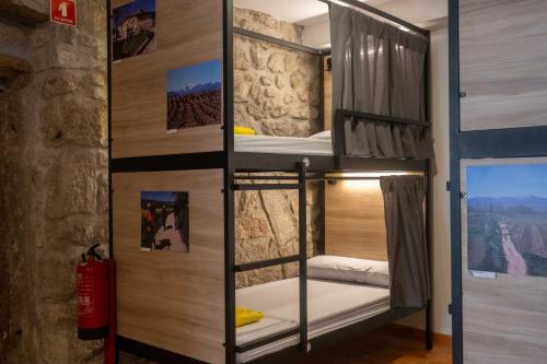 a bunk bed in a room with a wall at Albergue Santiago de Caminha in Caminha