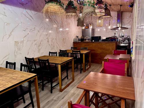 a restaurant with wooden tables and chairs and a counter at Albergue Santiago de Caminha in Caminha