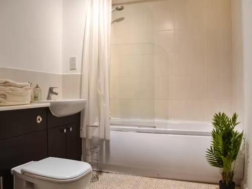 a bathroom with a tub and a toilet and a sink at Spacious 2-Bedroom Ground Floor Flat with 2 Double Beds, Sleeps 4 in Central Aberdeen in Aberdeen